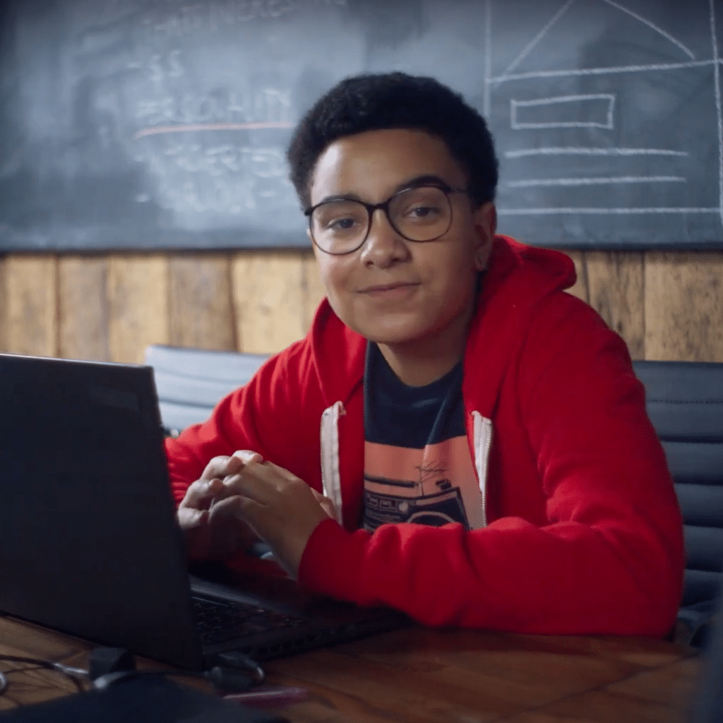 Image of kid in a red hoodie sitting at a laptop