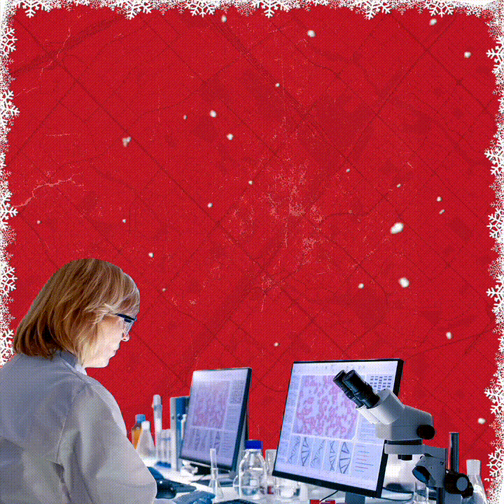 Lab technician sitting in front of a computer, over a red background. Animated text reads: "This mile: teaching supercomputers to predict cancer risk. The next mile: catching tumours before they spread. Donate today and let's reach #TheNextMile together."