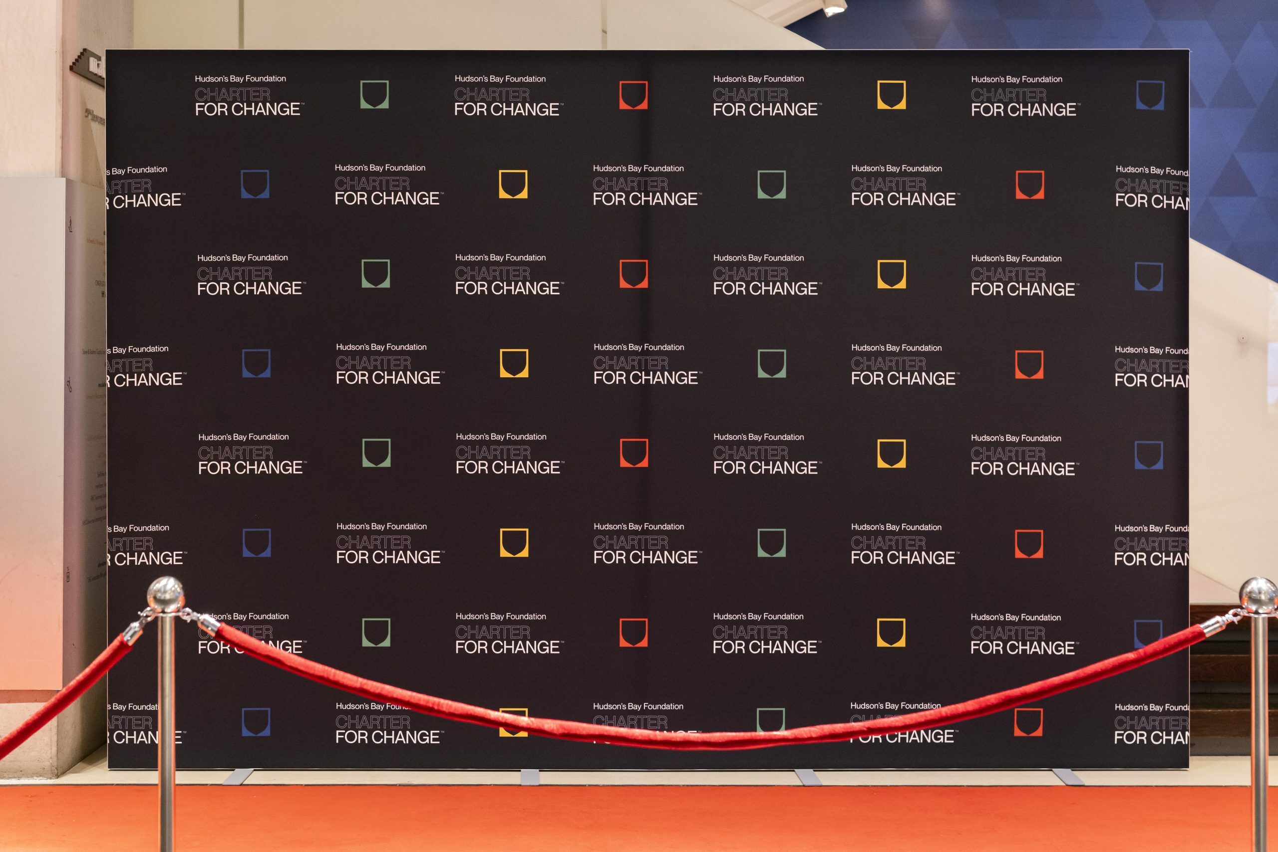 Hudson's Bay Foundation Charter for Change Step-and-Repeat photowall, with multicoloured crest icons and Foundation logos