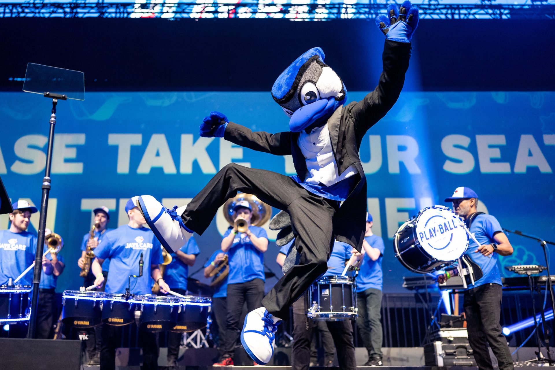 Blue Jays mascot doing a celebratory jump kick at the Play Ball charity event.
